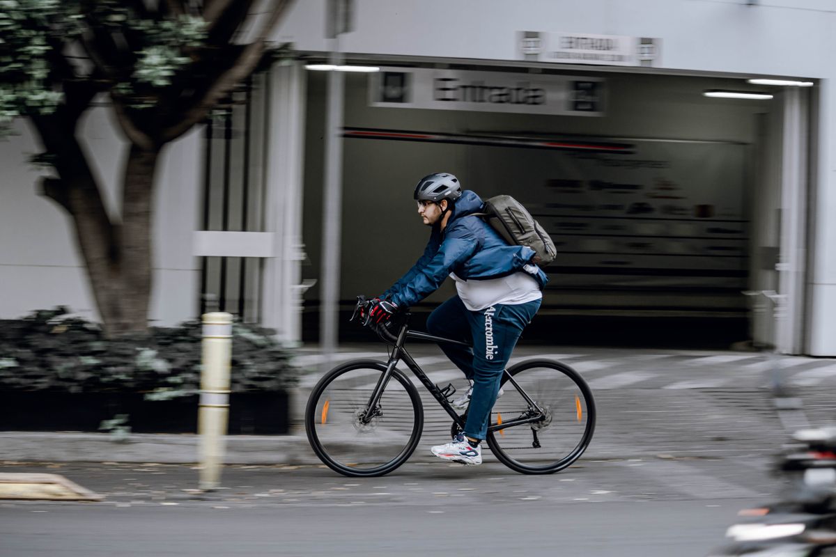 City bicycle commuter riding with a backpack and helmet