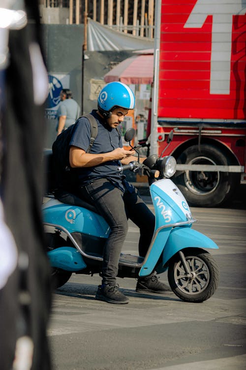 A Man Wearing Helmet Using Phone While Sitting on the Motorcycle