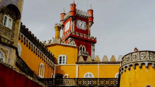 Free Explore the colorful architecture of Pena Palace's iconic clock tower in Sintra, Portugal. Stock Photo