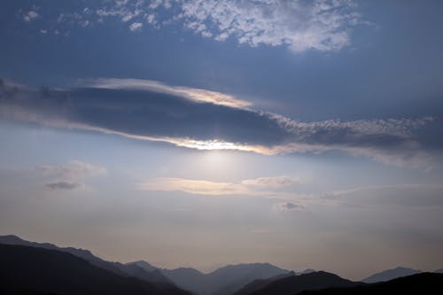 Silhouette of Mountains Under White Clouds and Blue Sky