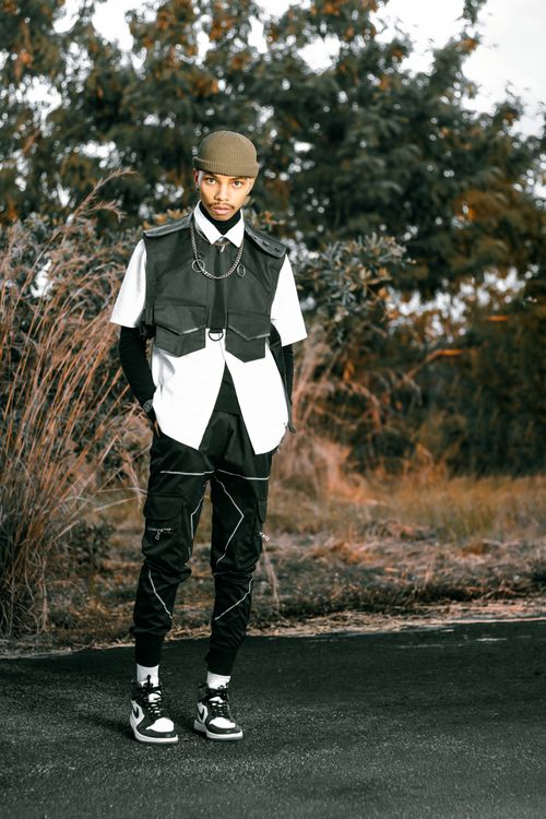 Free Stylish young adult male in outdoor streetwear fashion with nature backdrop. Stock Photo