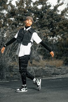 Stylish man posing outdoors in modern fashion attire.