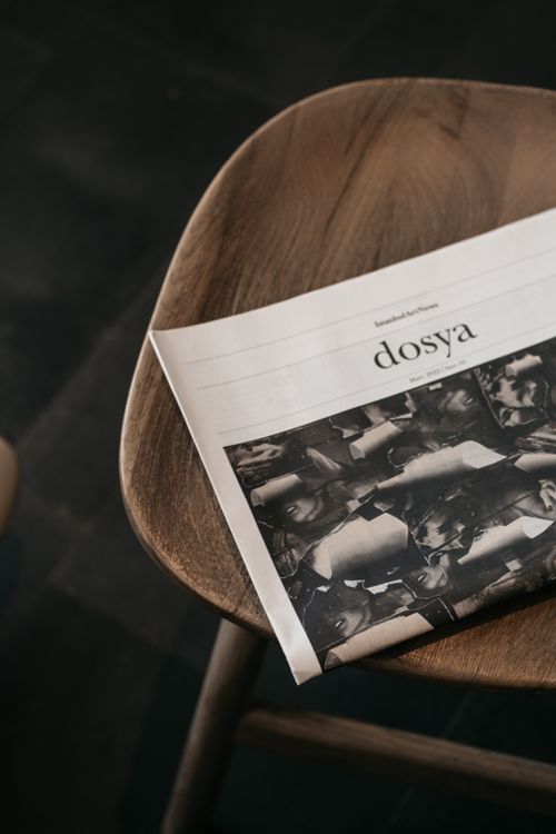 Free A close-up shot of a magazine resting on a wooden chair, creating a cozy and minimalist atmosphere. Stock Photo