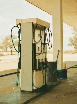 Rustic gas pump at an old, deserted gasoline station with nostalgic vibes.