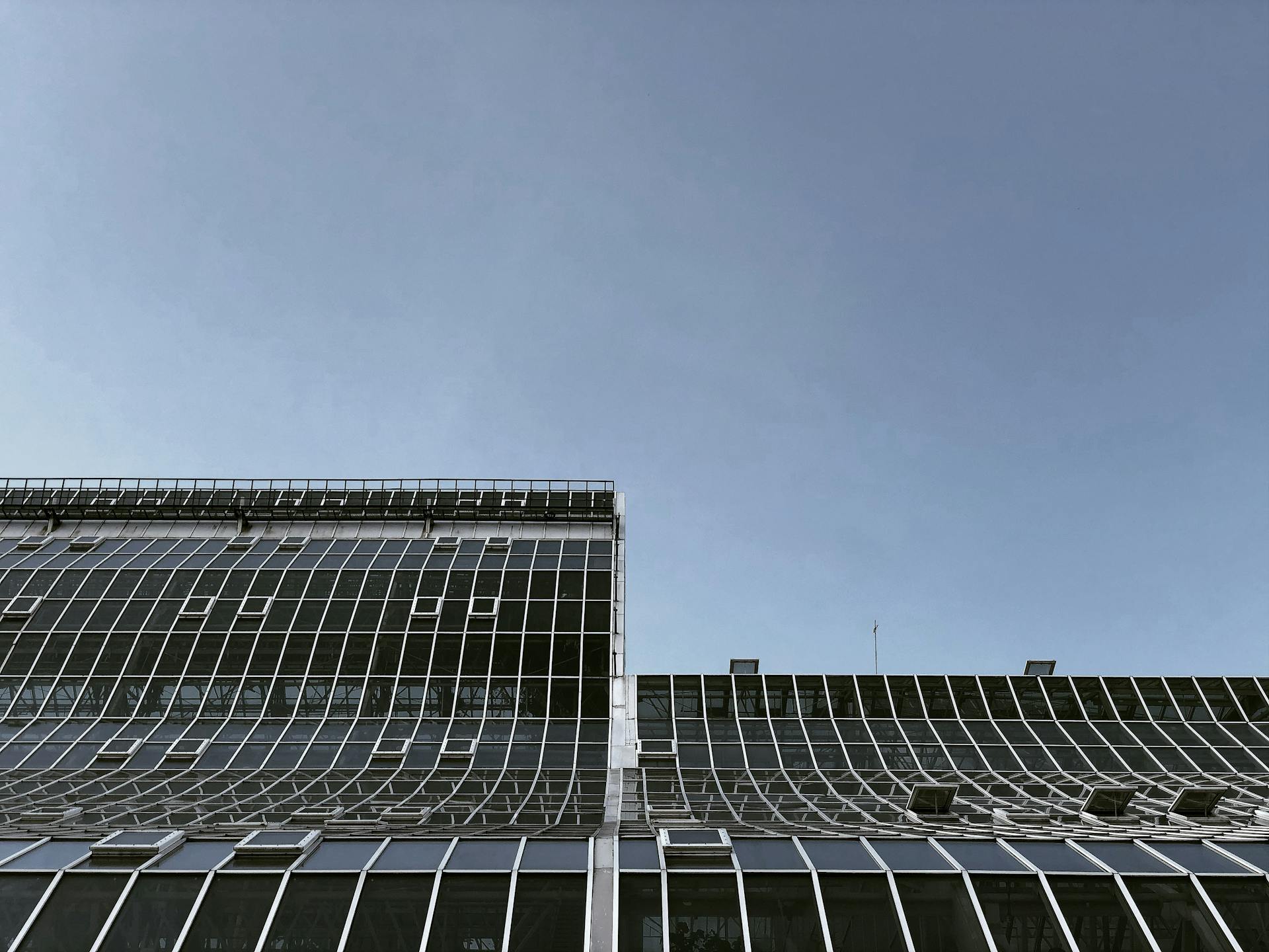 Contemporary building in Moscow with a glass facade against a clear blue sky, low angle view.