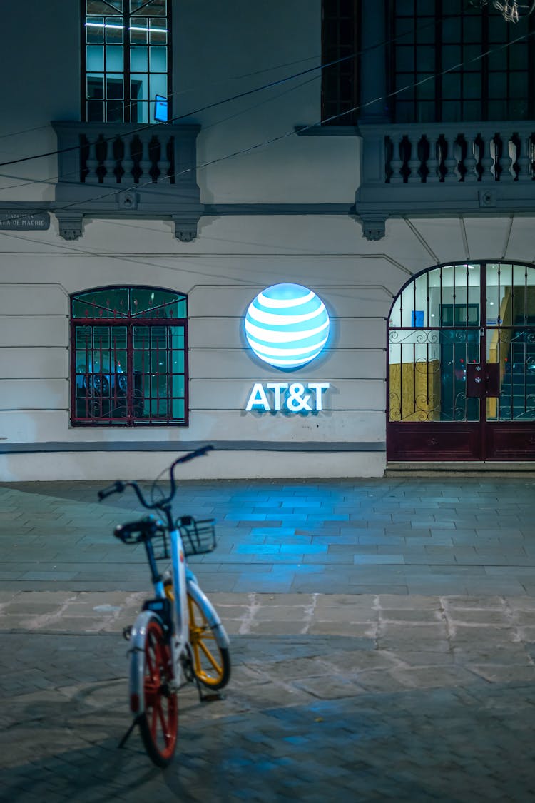 A Logo And Signage On Wall Illuminated At Night