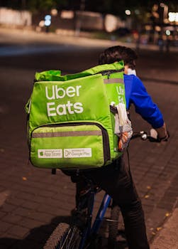 A delivery cyclist on a street at night with an Uber Eats backpack in Mexico City.