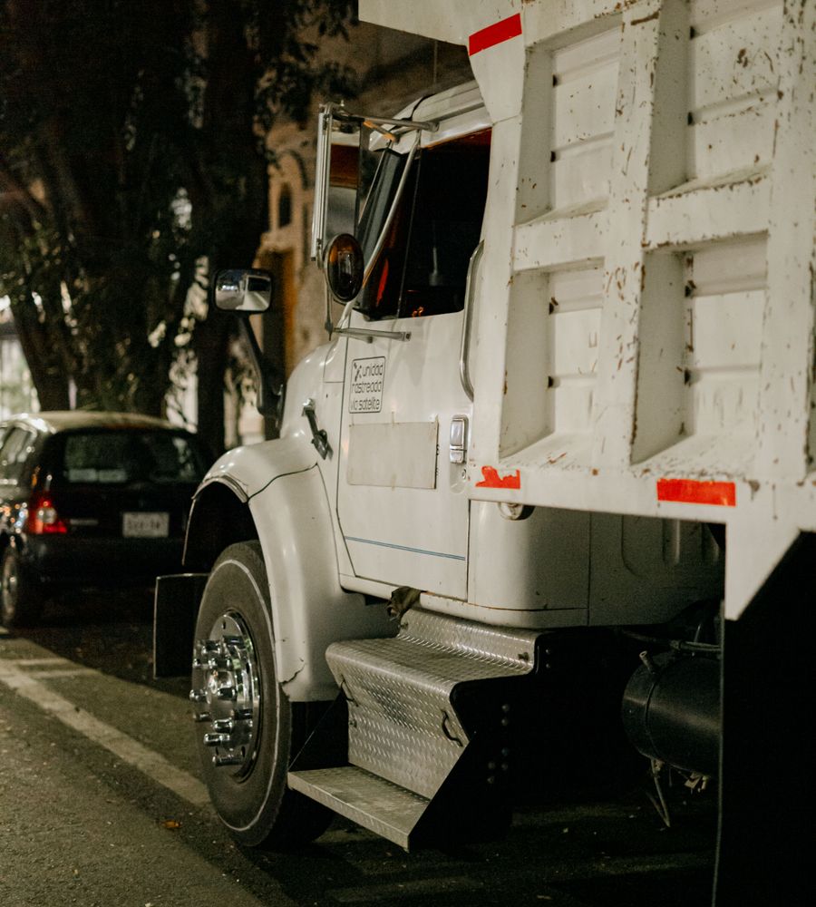 Camión de carga blanco estacionado en una calle de noche en la Ciudad de México