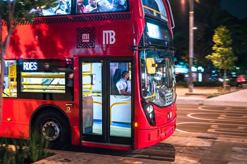 Free A vibrant red city bus transporting passengers at night in Ciudad de México. Stock Photo