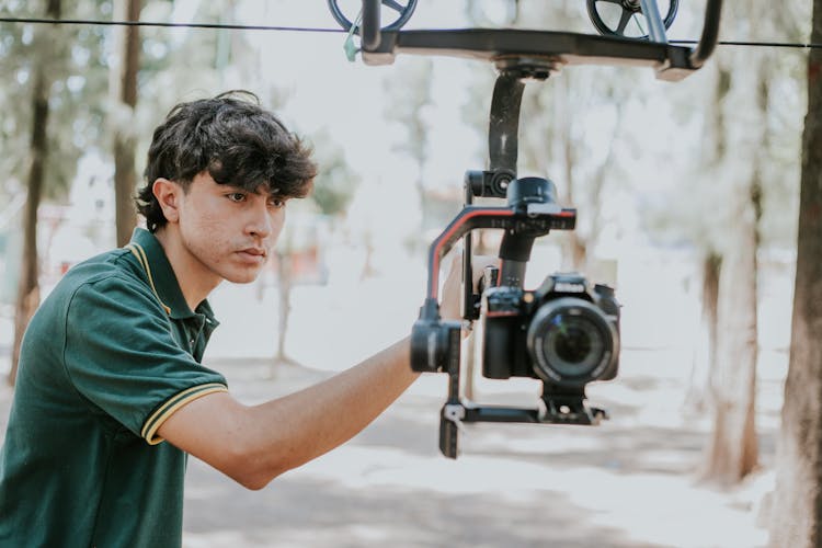 Man Filming With Professional Camera In Park