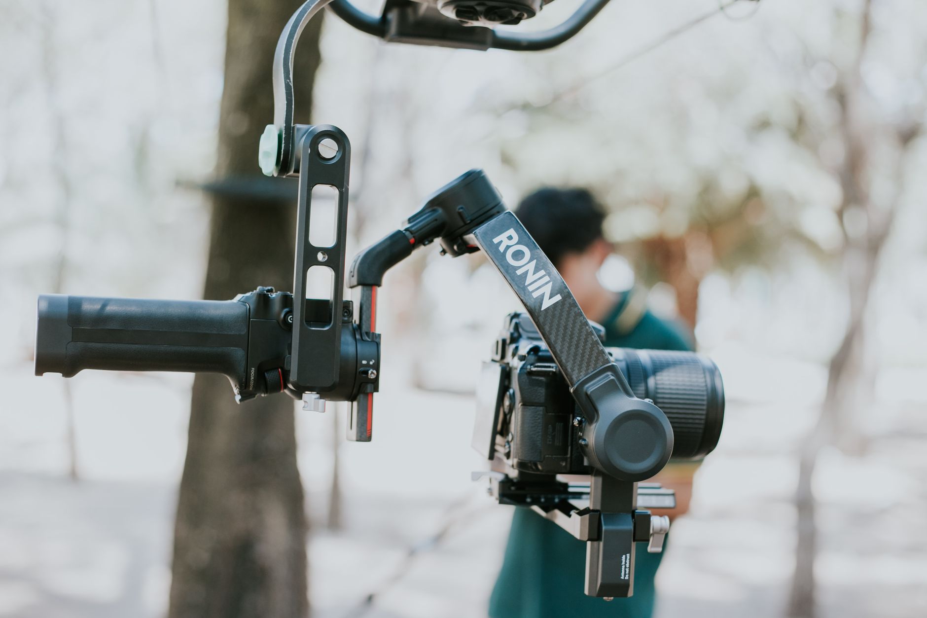 手持 vs 雲台:穩定器使用時機與選購指南 Close-up of a camera mounted on a Ronin stabilizer outdoors, capturing videography equipment in use.