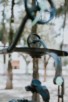 Artistic close-up of a contemporary metal structure with wheels outdoors.
