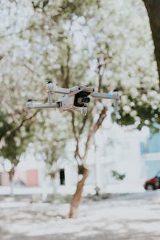 Close-up of a drone in flight among trees, showcasing modern technology.