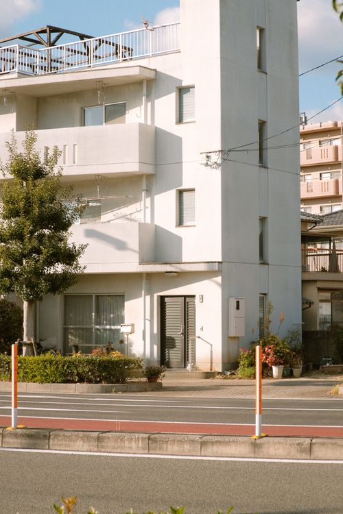 Free A contemporary apartment building featuring balconies and glass windows on a sunny day. Stock Photo