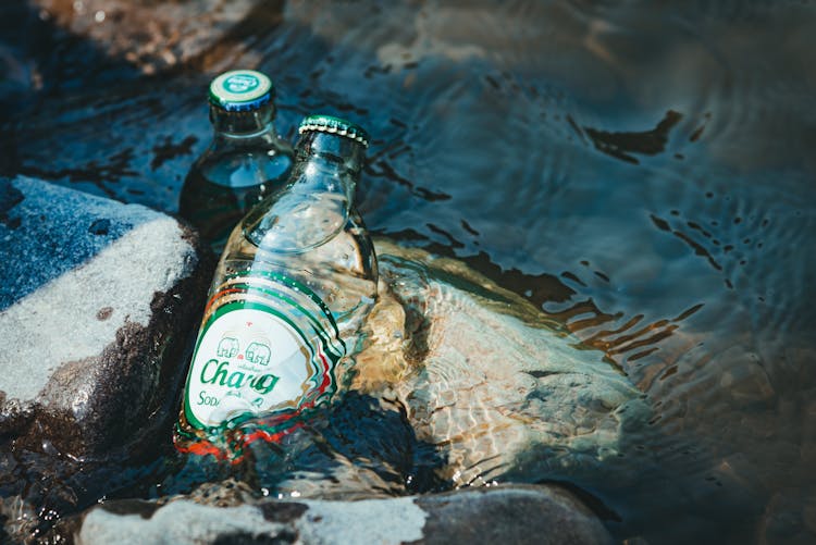 Soda Bottles On Rocks In Water