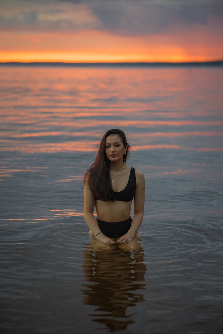 Woman In Water At Sunset