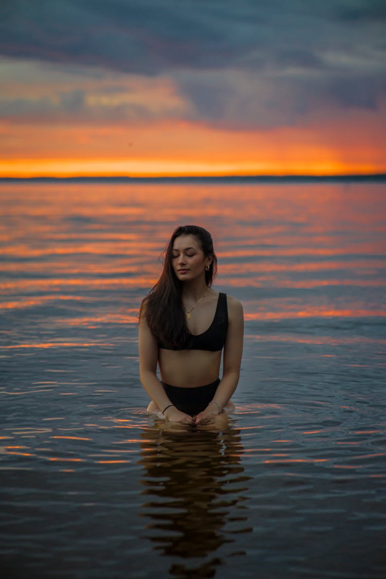 Woman In Water At Sunset