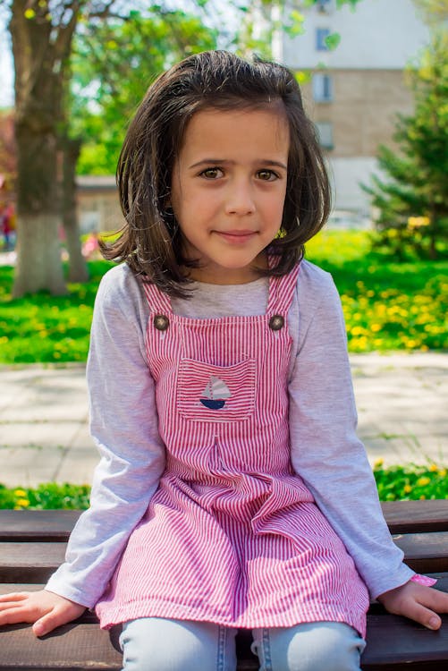 Girl in Pink Jumper Sitting on Bench