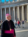 Man in Red and Black Robe Standing on Street