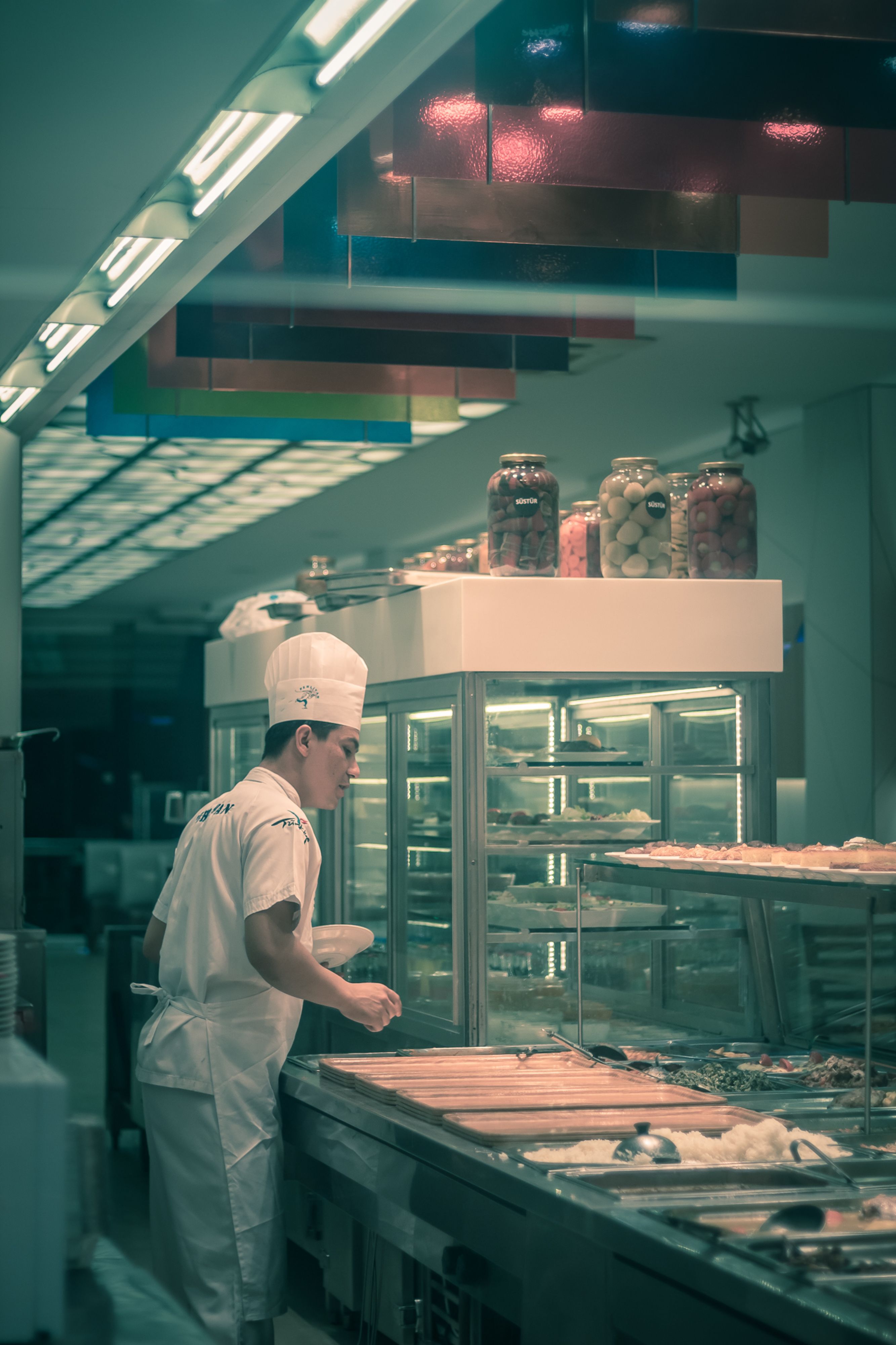 Cuisinier au poste de service dans une cuisine de restauration collective