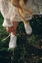 Woman in White Lace Dress Untying Trainers