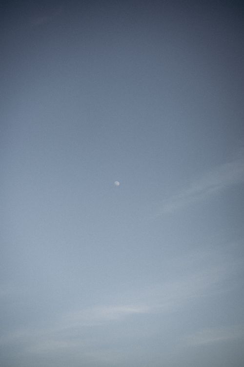 Free Tranquil sky scene featuring a distant moon against a blue backdrop, ideal for peaceful themes. Stock Photo