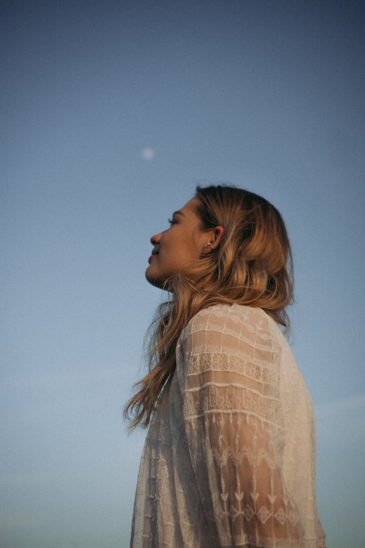 Woman Wearing A White Sheer Top Looking Up