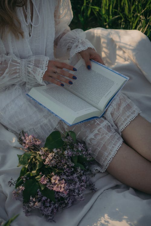 Free Woman in White Lace Dress Holding a Book Stock Photo