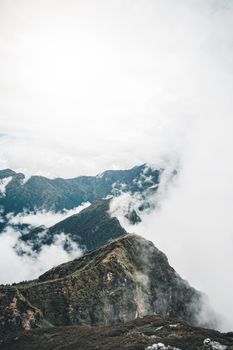 Stunning view of a mountain peak shrouded in clouds, capturing the serene beauty of the Himalayas in India.