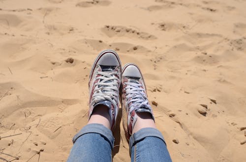 Person's Feet on Brown Sand
