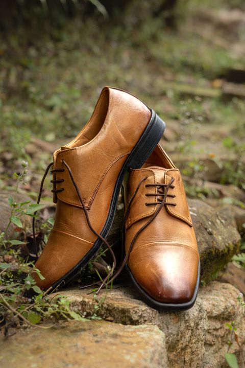 Tan leather oxford shoes on rocks