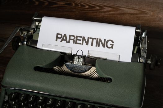 Close-up of a vintage typewriter typing the word 'PARENTING' on paper.