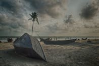 考克斯巴扎尔宁静的海滩上，有小船、棕榈树和多云的天空