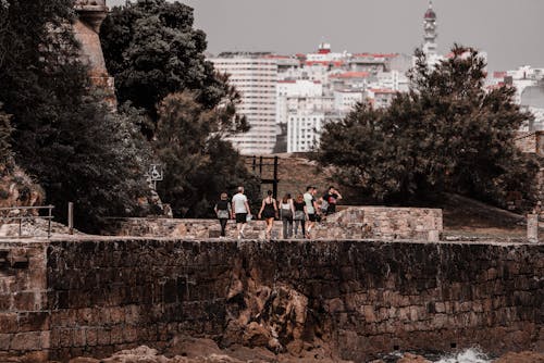 Group of People Walking on a Path in the Park with the View of a City in Lisbon, Portugal