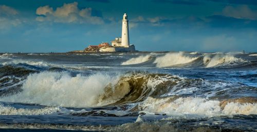 Free Dramatic waves crashing near St. Mary's Lighthouse in the UK during a clear day. Stock Photo