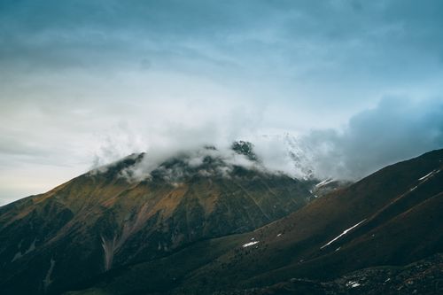 Free A stunning view of mountain peaks partially covered by clouds, showcasing nature's beauty. Stock Photo