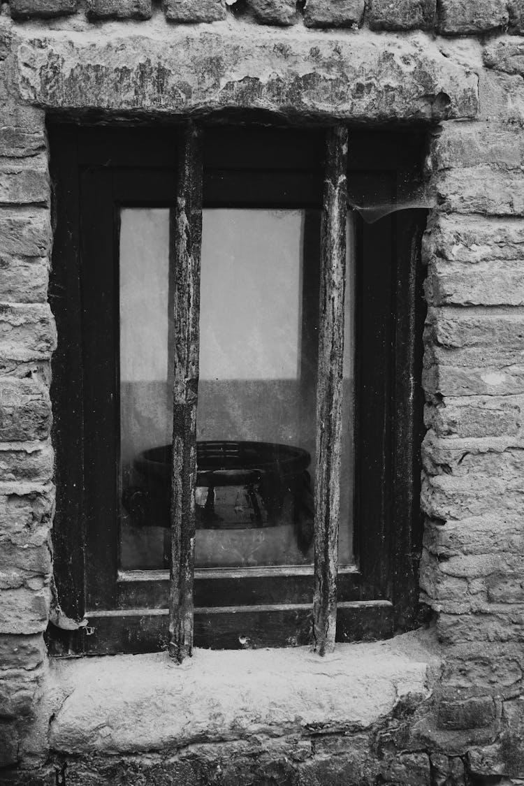 Black Wooden Framed Glass Window On Stone Wall