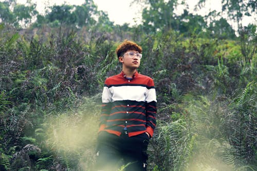 A Man Standing Beside Green Plants