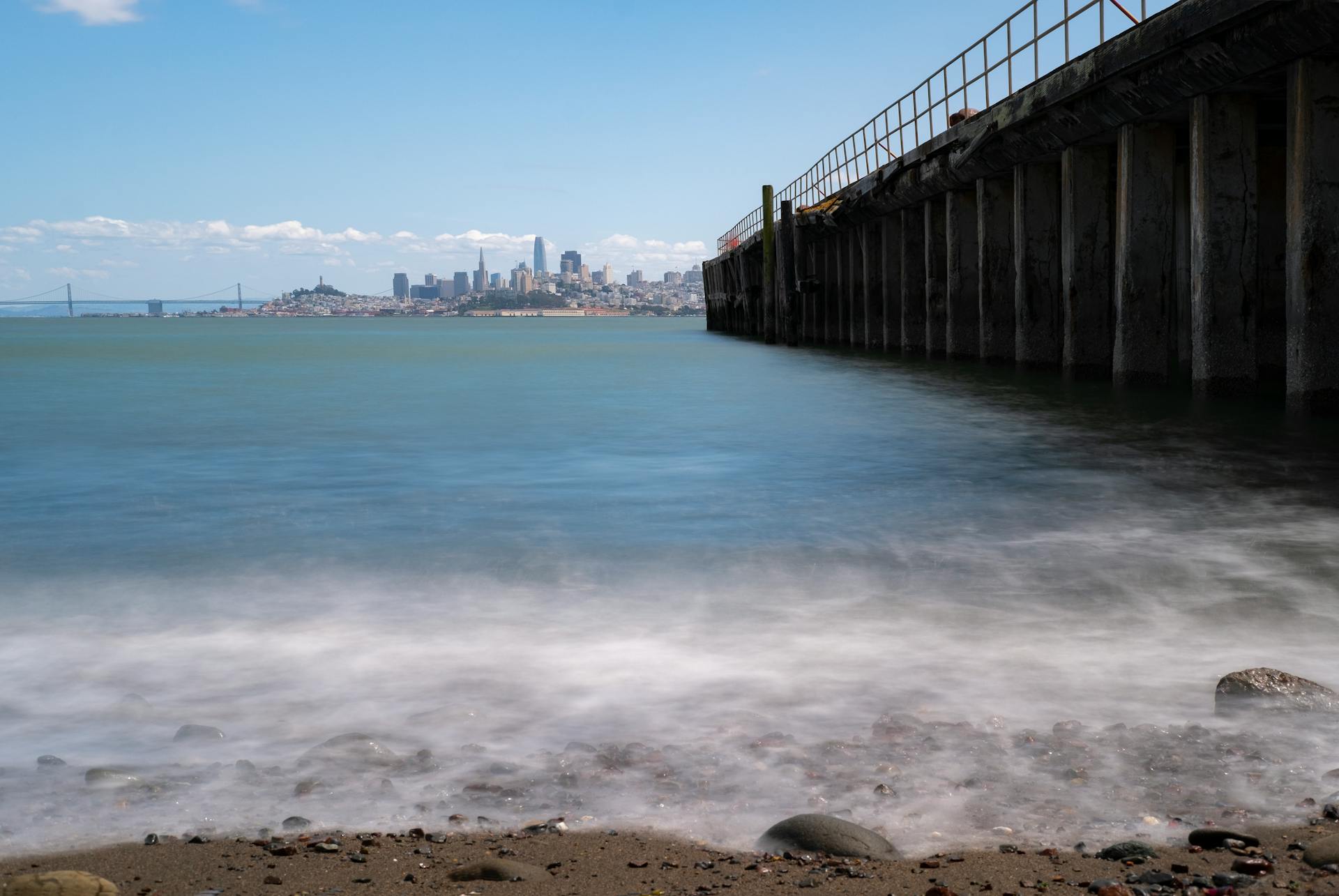 Calm bay scene with a city skyline and pier, perfect for travel inspiration.