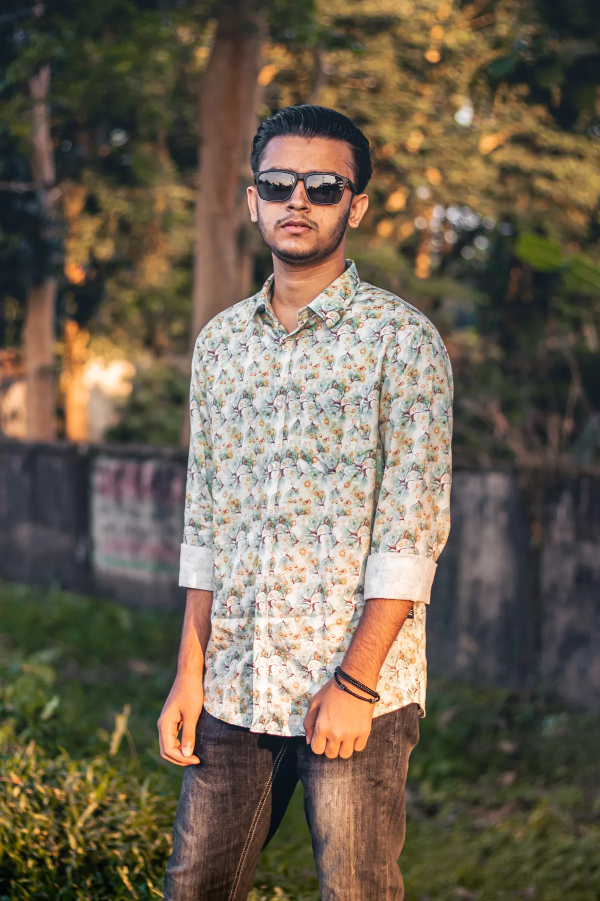 Pemuda mengenakan outfit warna terang berkontras dengan background dinding netral untuk fokus subjek dalam frame