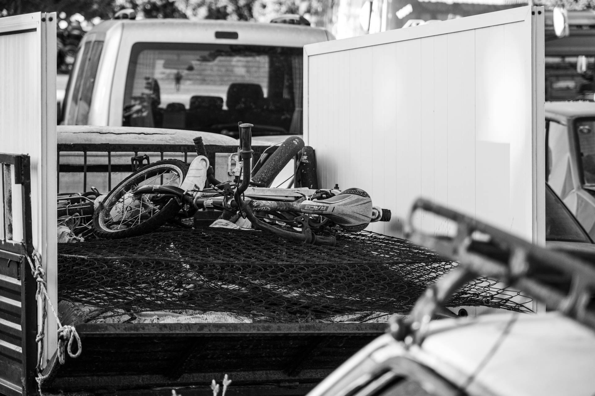 Grayscale Photo of Bicycle at the Back of a Truck