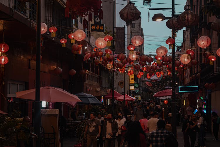 People Walking On Street With Hanging Lanterns