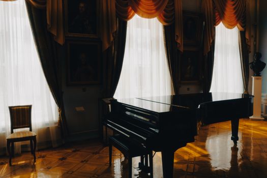 A grand piano in a sunlit room with elegant drapes and classic decor, enhancing a luxurious atmosphere.