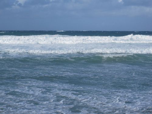Free Powerful ocean waves crashing under a cloudy sky, showcasing the sea's raw beauty. Stock Photo