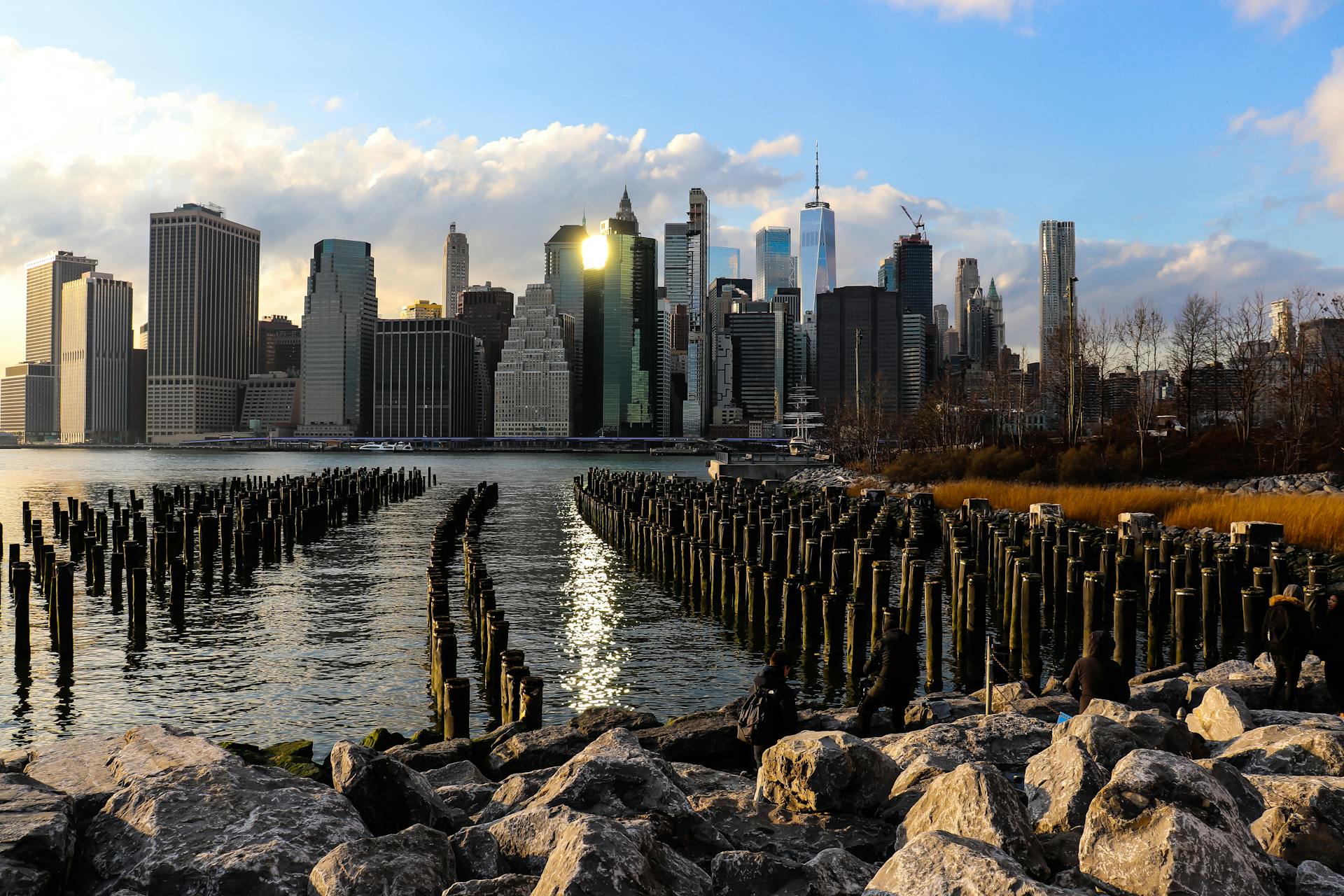 Stunning view of New York City skyline from the waterfront with old piers in foreground.