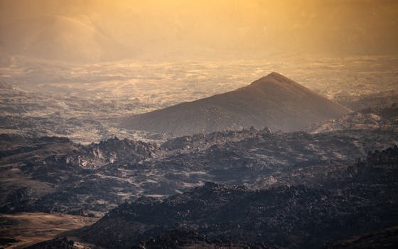 A breathtaking view of Tenerife's volcanic terrain at sunset, highlighting rugged mountains and warm tones.