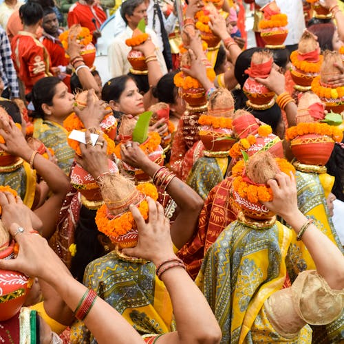 Crowd of People Carrying Vases on Their Heads