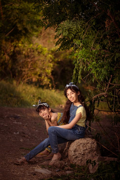 happy Siblings sitting under a Tree