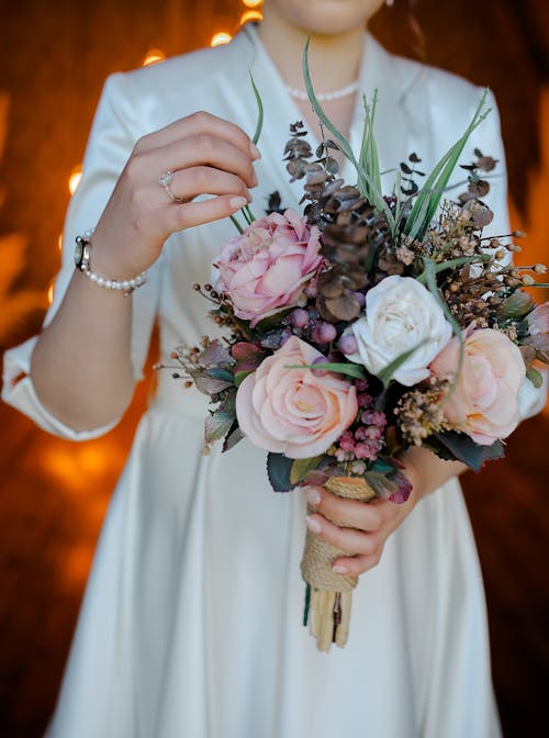 Woman in White Dress Holding Bouquet of Roses