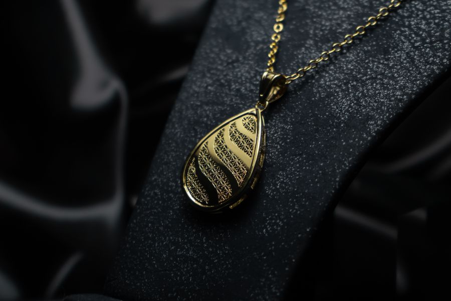 Close-up of an intricately designed gold necklace pendant